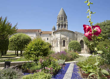 Jardins fleuris avec vue sur le clocher de l'abbaye